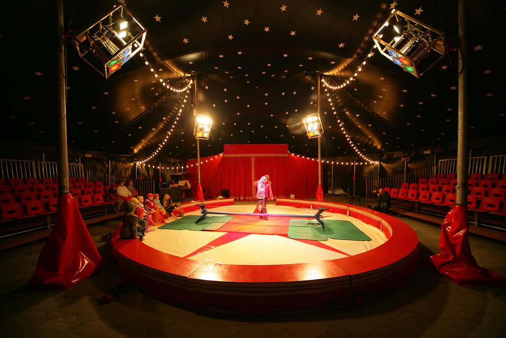 Eine runde Zirkusmanege mit Sternenzeltdach.